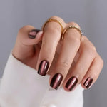 Load image into Gallery viewer, Hand with metallic nail polish and gold rings on a neutral background