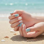 Load image into Gallery viewer, Close-up of hands with pastel nail polish on a beach