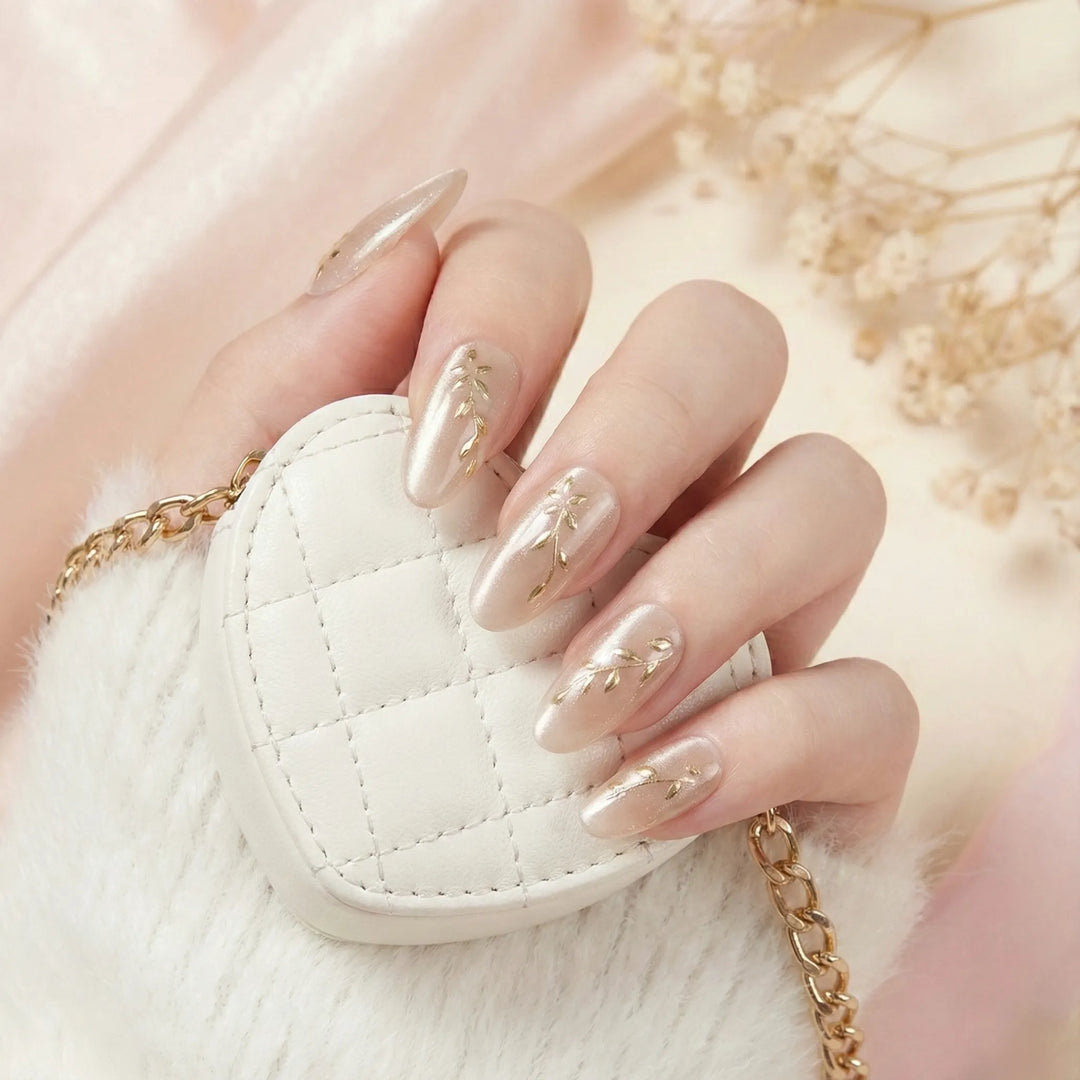 Hand with gold nail design holding a small white handbag with gold chain